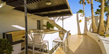 	Terraza con mesa y butaca del bungalow superior magnifique de las IFA Villas Altamarena	