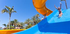 Fille sautant sur le toboggan de la piscine du lac de l'Abora Interclub Atlantic by Lopesan Hotels