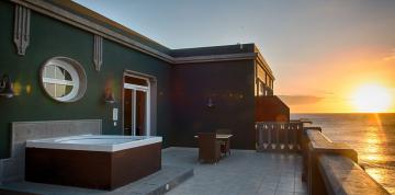 	Terraza con jacuzzi privado en la Superior Suite del hotel Lopesan Villa del Conde Resort & Thalasso  al atardecer	