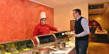 	Cheff y huésped en el interior del buffet del hotel IFA Breitach	