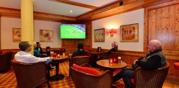 Invités regardant le football au bar de l'hôtel IFA Alpenrose