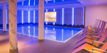	Hallenbad und Liegestühle Wellnessbereich IFA Alpenrose Hotel 	