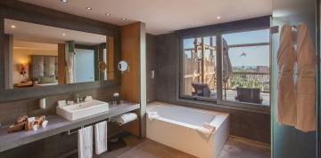 Intérieur de la salle de bain dans les chambres doubles supérieures du Lopesan Baobab Resort avec une fenêtre sur la terrasse