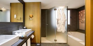	Interior del baño con ducha y bañera de las Junior Suites del Lopesan Baobab Resort	
