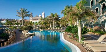 Palmeras alrededor de la piscina VIP del hotel Lopesan Villa del Conde