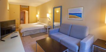 	Sillón y cama de las habitaciones doble familiar del hotel IFA Altamarena	