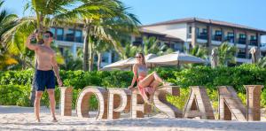 joven-pareja-letrero-lopesan-playa-lopesan-costa-bavaro-resort-spa-casino-punta-cana-republica-dominicana	