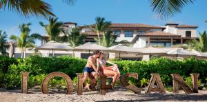 pareja-letrero-lopesan-playa-lopesan-costa-bavaro-resort-spa-casino-punta-cana-republica-dominicana	